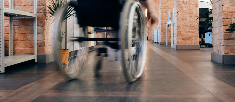 Photo of a wheelchair moving down a corridor
