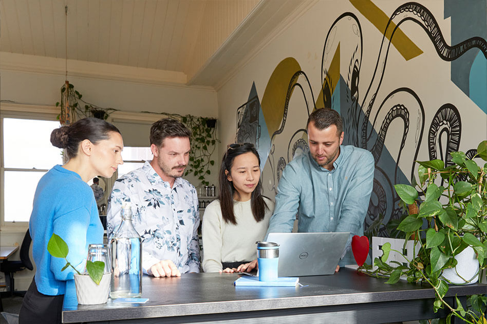 Team Lemonade huddling round a laptop