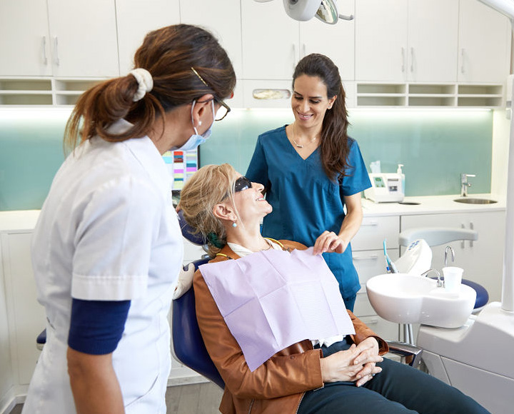 2 dentists and a patient smiling